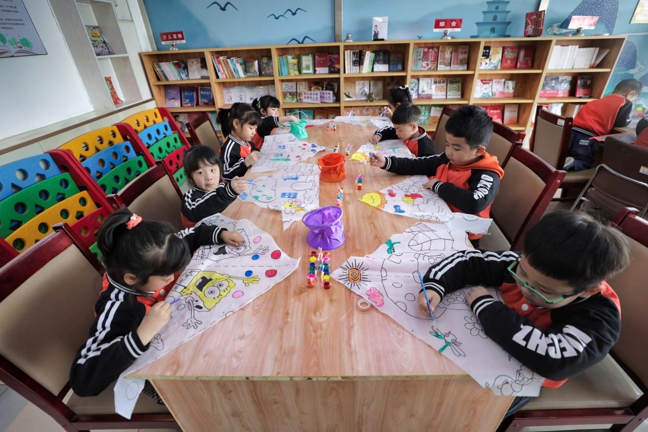 在河北省唐山市豐南區黃各庄鎮圖書館內，孩子們一起手繪風箏。畢帥攝