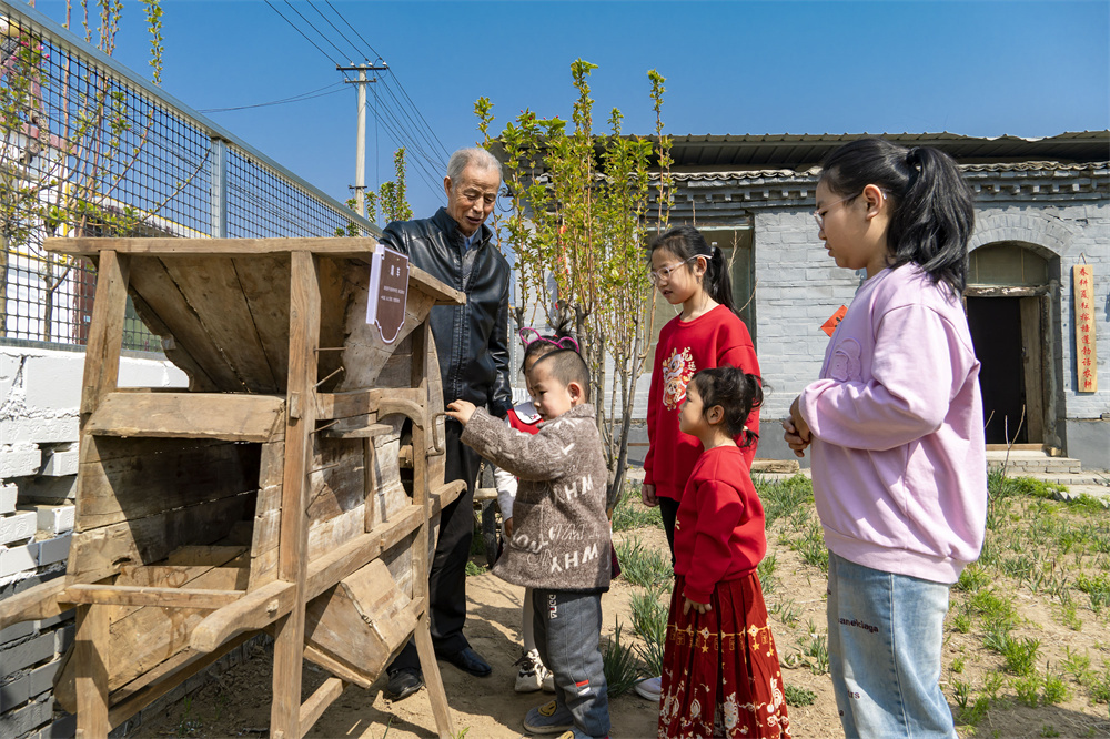在高阳县小王果庄镇傅家营村“乡村记忆馆”内，孩子们在村民指导下体验扇车。范宝全摄