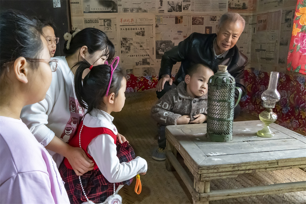 在高阳县小王果庄镇傅家营村“乡村记忆馆”内，孩子们在村民讲解下观看老式油灯、暖壶。芦建勇摄