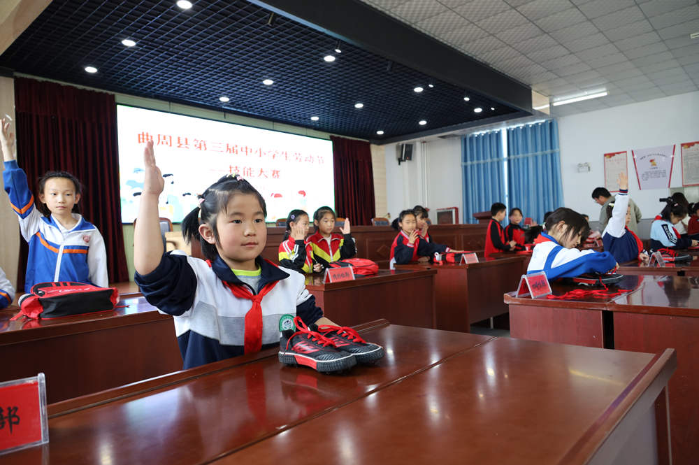 学生们正在参加“系鞋带”比赛。韩晓宁摄