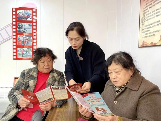 圖為小山街道工作人員為居民解讀國家安全宣傳手冊。張瑾攝。