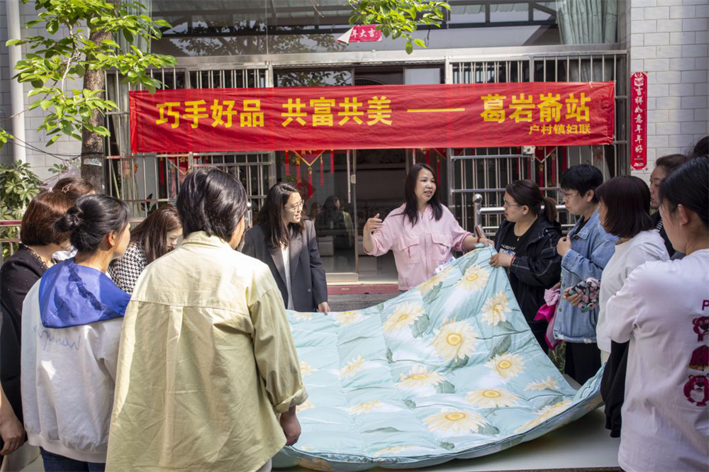 4月17日，河北省邯鄲市復興區戶村鎮葛岩崳村，村民孔紅霞（中間）在自家庭院為全鎮16個村的婦聯主任講解“舊羽絨服制作羽絨被”。聶長青攝