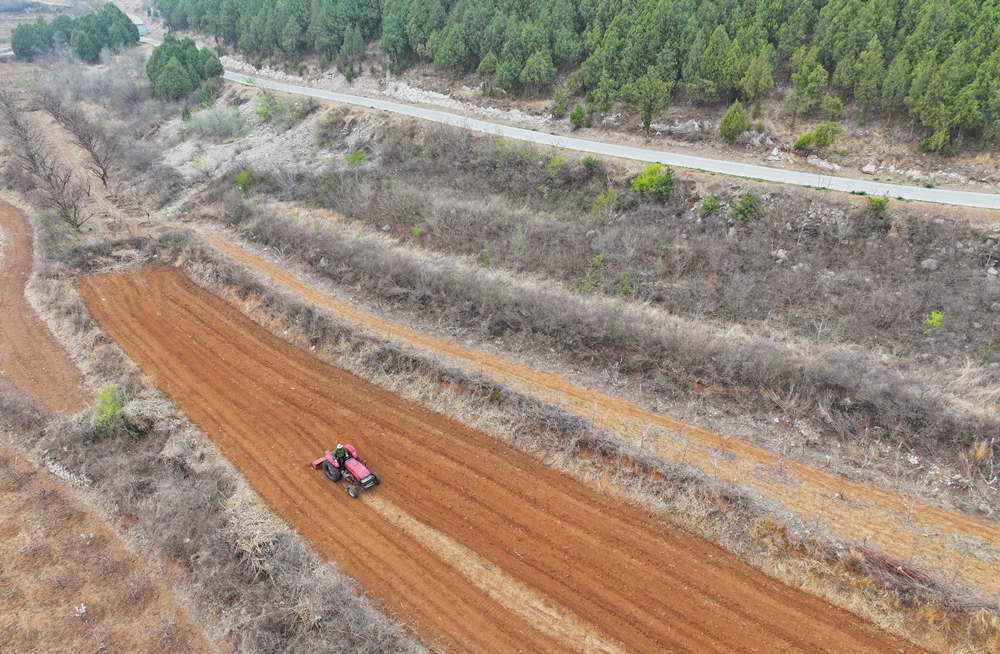 蔣福山山間田地裡，村民駕駛耕地機在田間犁地。劉向攝