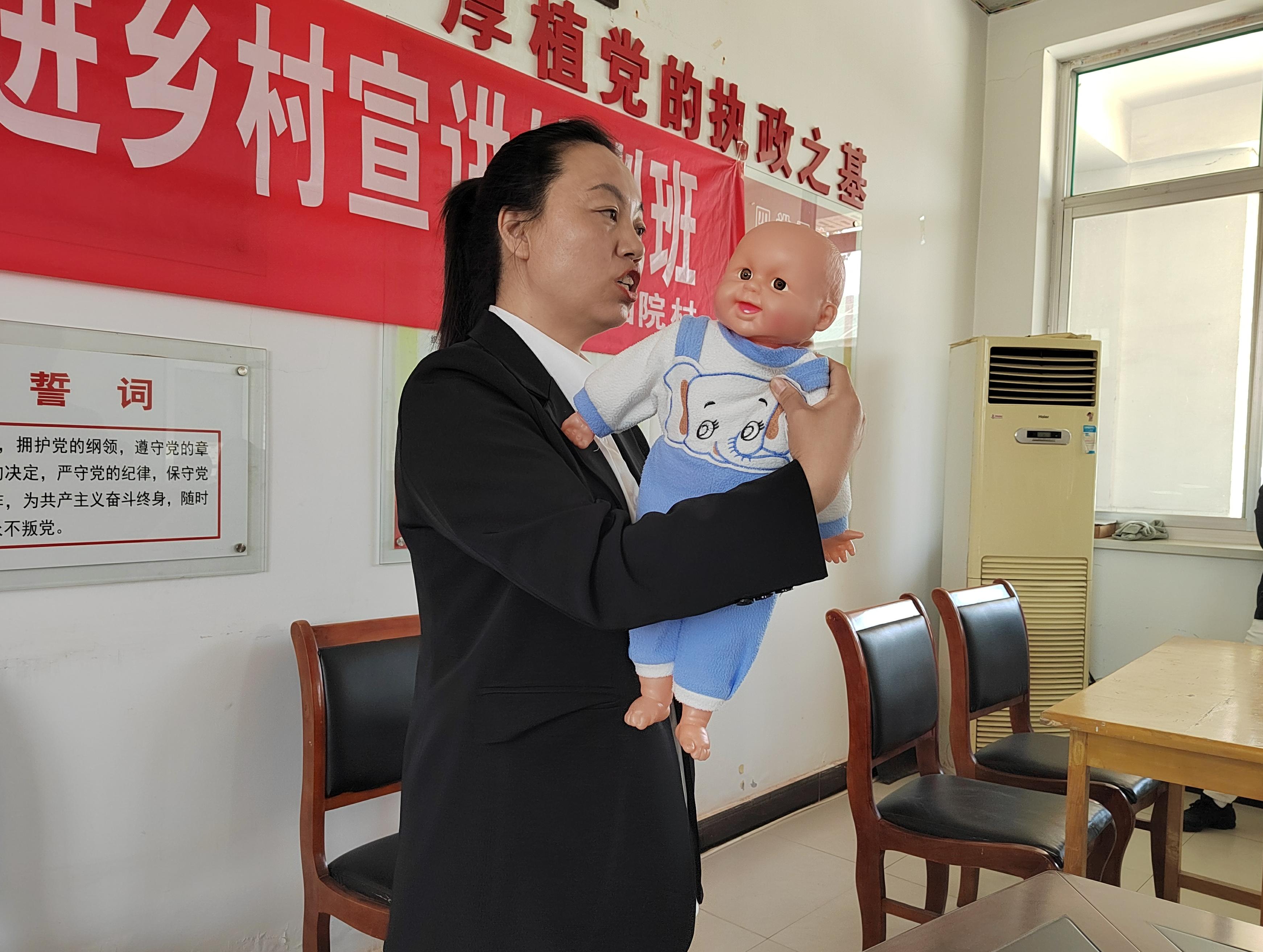 4月18日，在河北省遷安市大崔庄鎮下金山院村，育嬰師正在借助仿真娃娃講解育嬰實操。全子陽 攝
