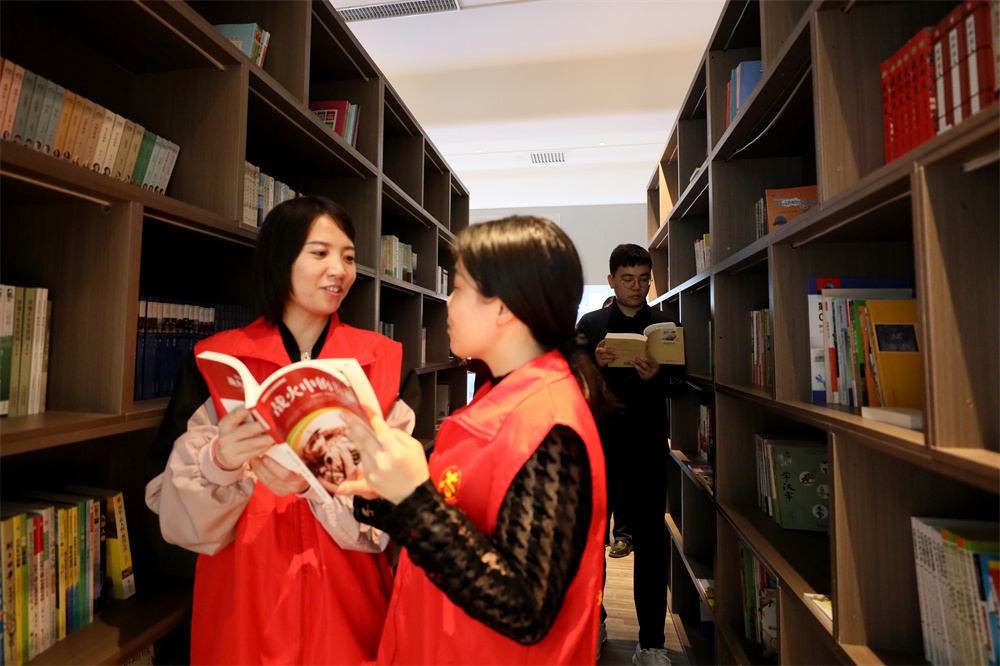 在河北省隆尧县汦河社区，志愿者和辖区居民在观看图书。成梅摄