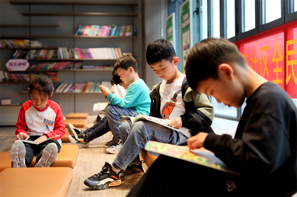 在河北省隆尧县汦河社区，辖区小朋友在观看图书。成梅摄