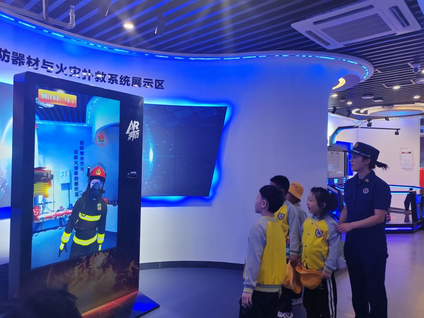 4月23日，在河北省高碑店市消防救援大队的消防安全体验馆里，消防员正带领小朋友们体验AR消防器材与火灾扑救系统。朱珊珊摄