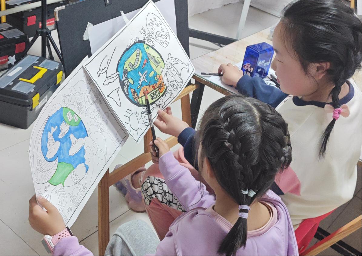 孩子们互相交流自己的绘画作品。罗桂滨摄