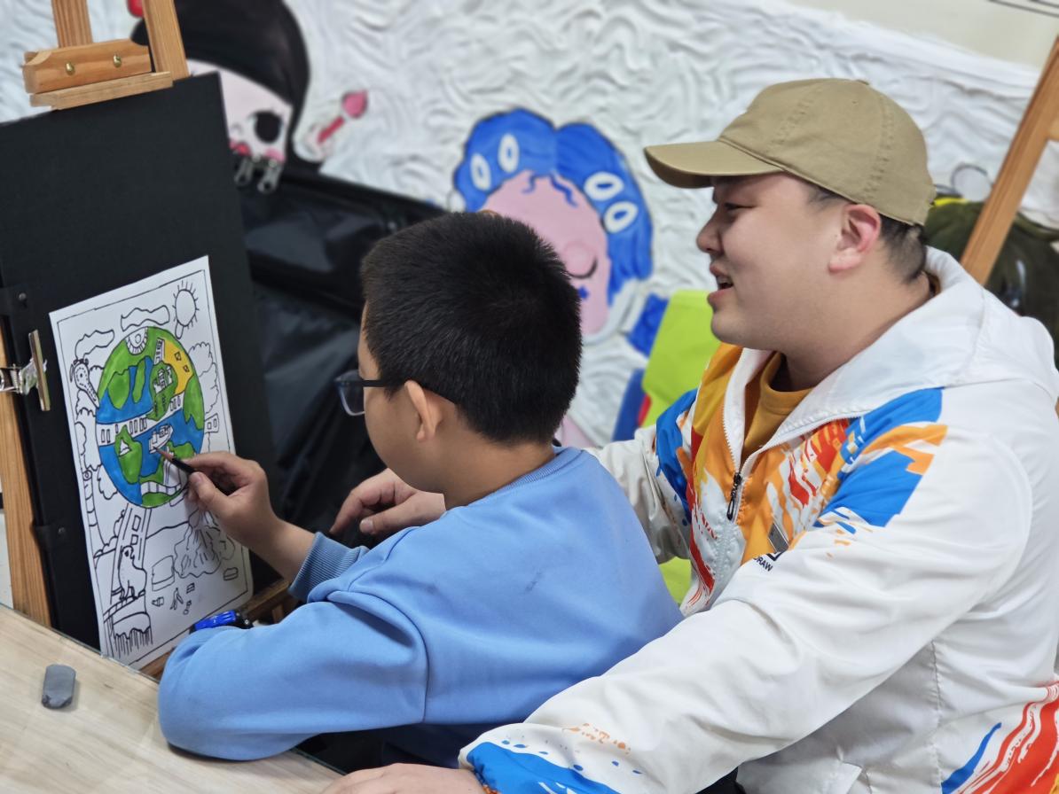 孩子们在马文博的指导下绘出自己心中最美的地球家园。罗桂滨摄