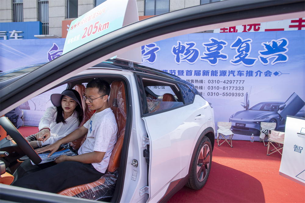 4月26日，邯鄲市復興區華北汽車城，顧客（右）在新能源樣車體驗參觀和咨詢。聶長青攝