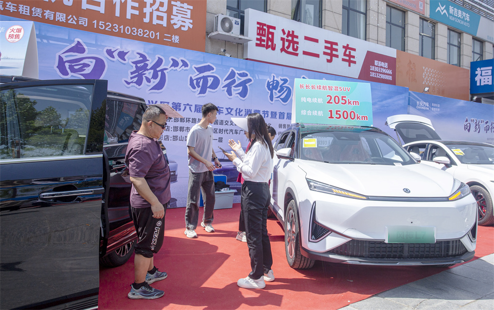 4月26日，邯郸市复兴区华北汽车城，顾客（左）在新能源样车体验参观和咨询。聂长青摄