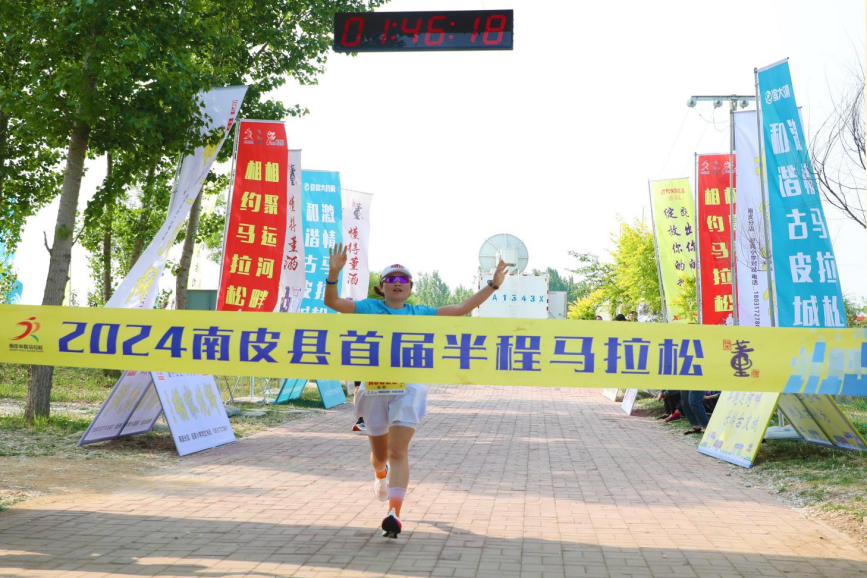 半程馬拉鬆女子組第一名沖過終點線。潘毅攝