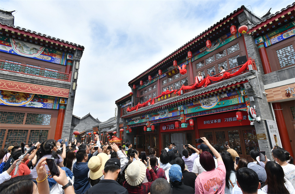 5月1日,游客在南川老街觀賞繡球招親節目。苑立偉攝