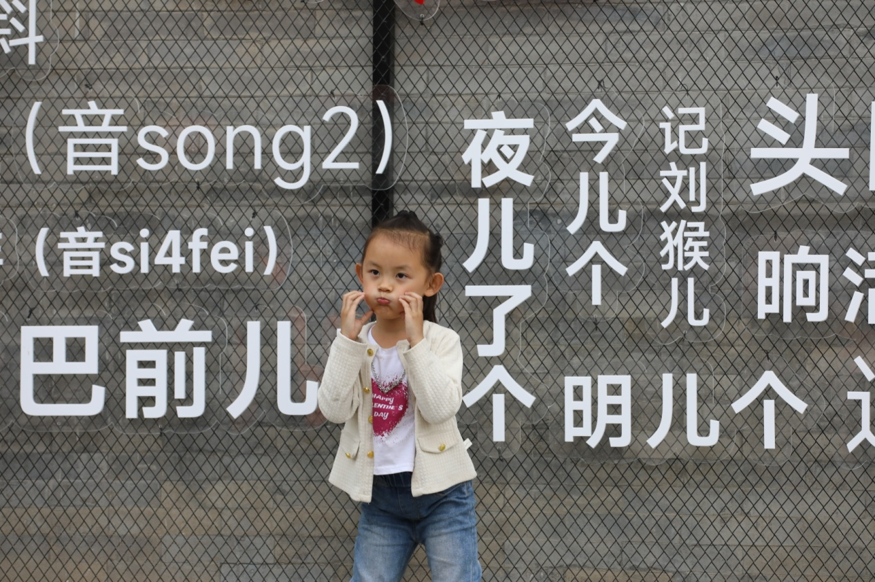 5月5日，一名小女孩在沧州坊内的沧州方言墙边打卡。陈卫民摄