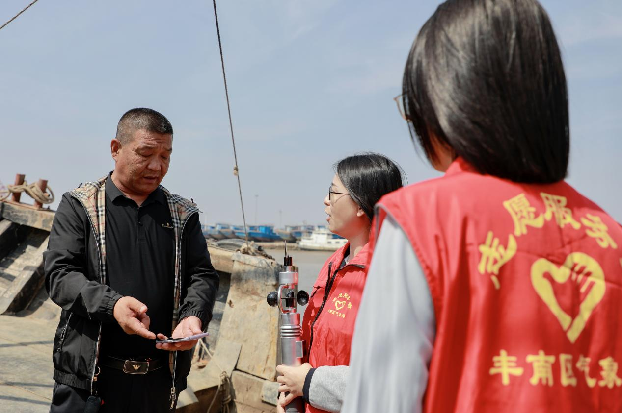 豐南區氣象局工作人員在為漁民講解防災減災知識。陳軍攝
