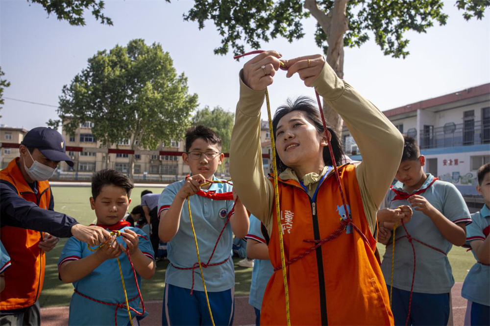 邯郸市红十字中安防减灾服务中心志愿者教孩子们绳结大比拼。聂长青摄