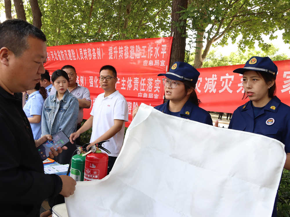消防救援大隊工作人員講解滅火毯使用方法。吳若涵攝