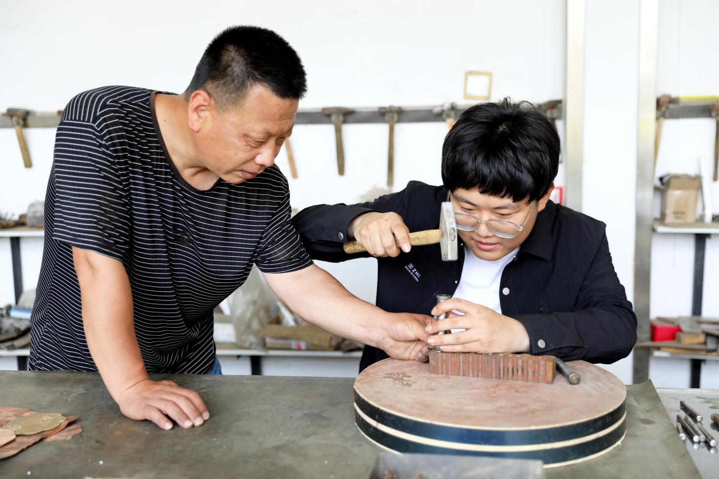 王春友指导手工艺爱好者进行錾铜作品制作。赵华靖摄