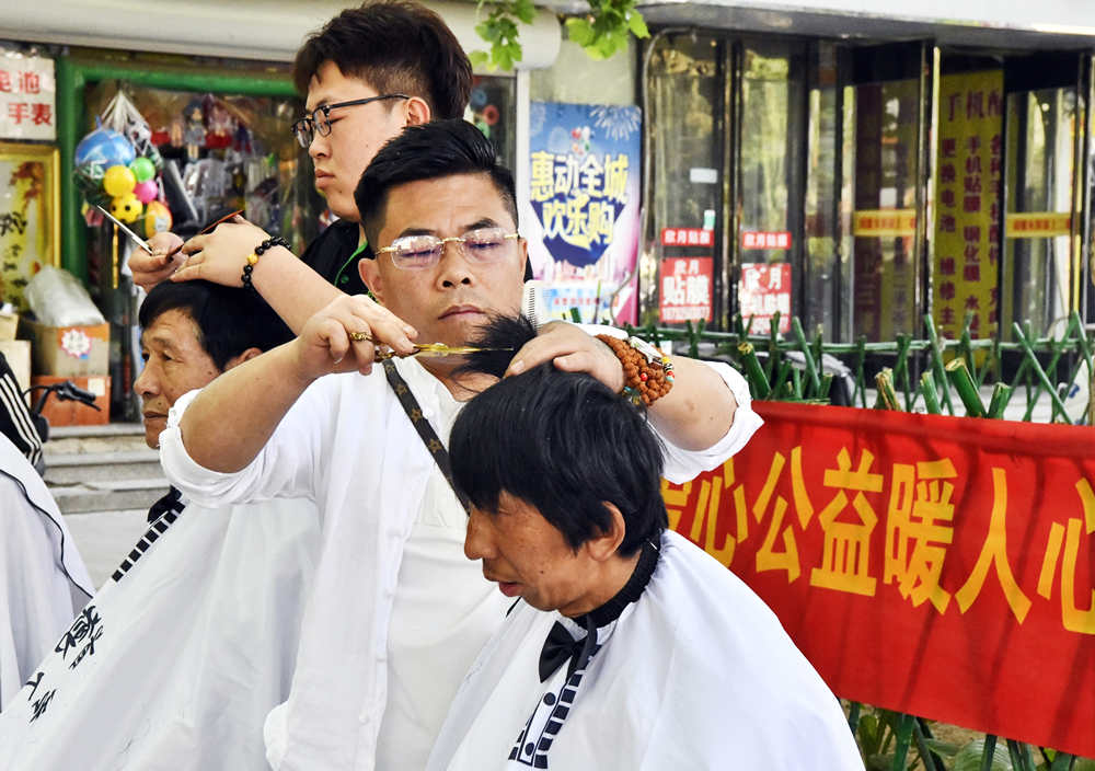 在迁安市文化广场，志愿者免费理发。杨硕摄