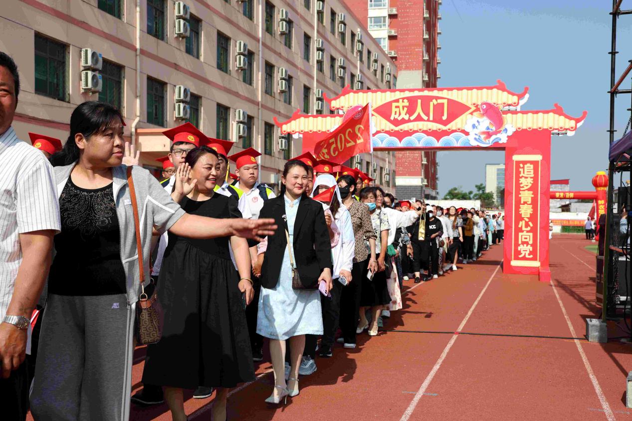 5月17日,成人礼活动上,家长陪同孩子一同通过“成人门”。田志锋摄