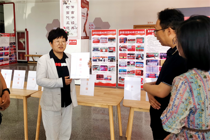 篆刻爱好者刘福玲正在展示讲解自己的作品。杨洋摄