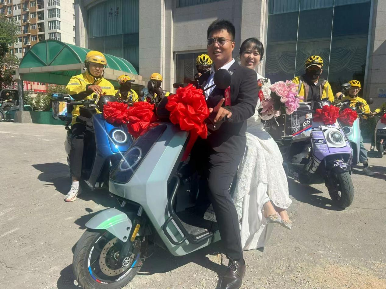 新郎騎著送餐車接上新娘出發。王景良攝