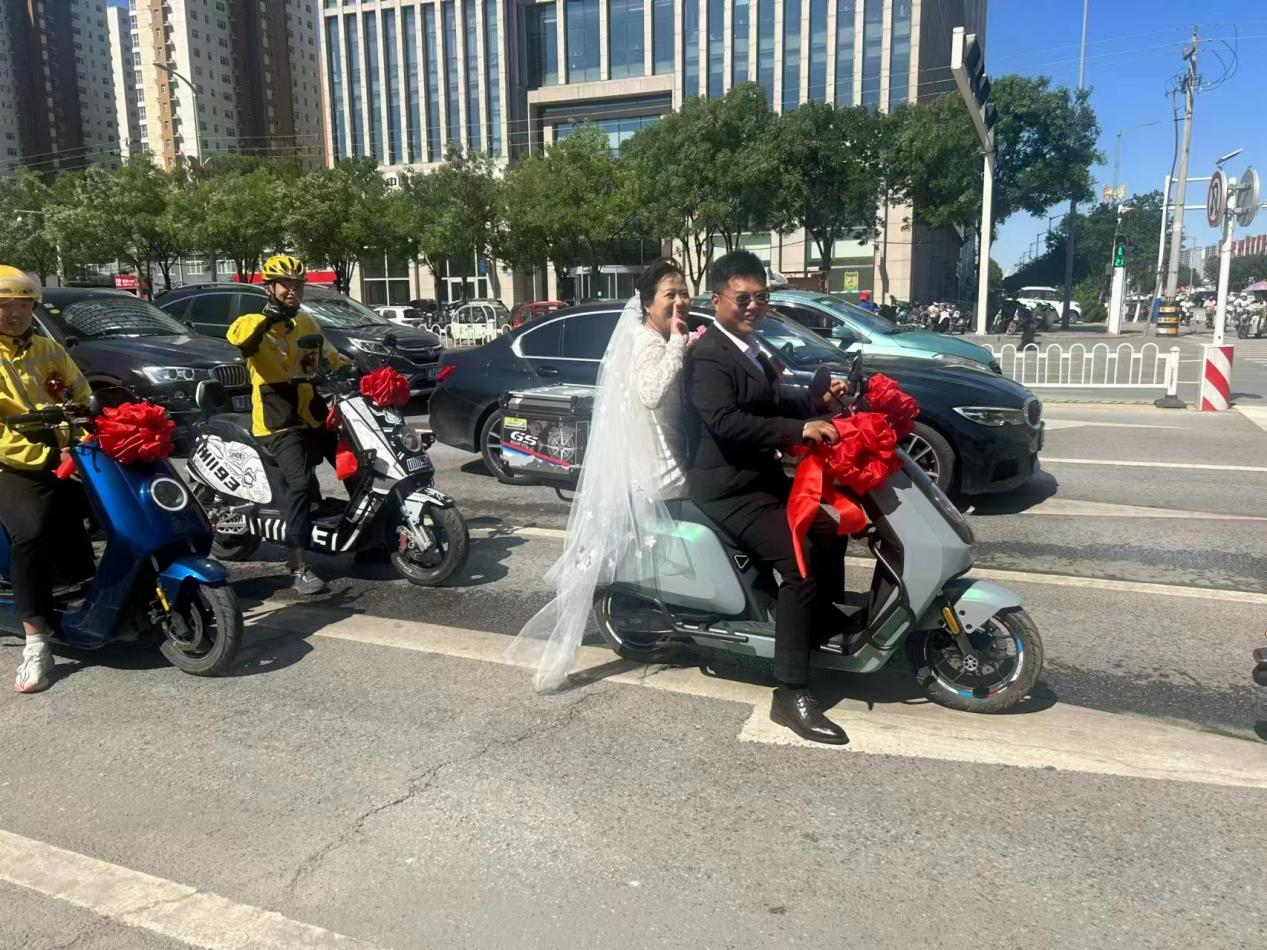 新娘坐在送餐車上滿臉笑容。王景良攝
