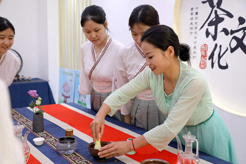 茶艺老师为学生们示范茶筅击拂的手法。吴梦莹摄