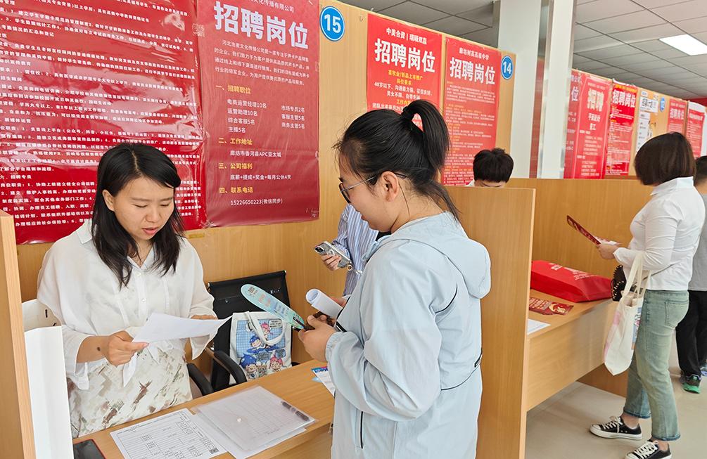 招聘會現場，企業招聘人員了解求職者簡歷。王延熙攝
