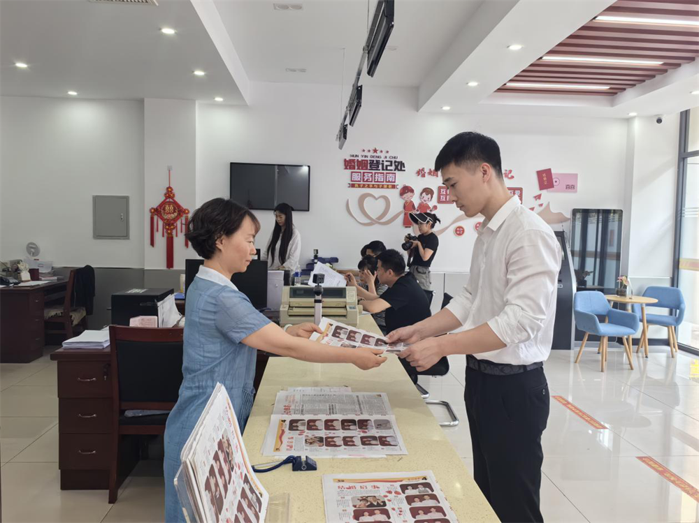 新人领取刊登自己结婚启示的报纸。赵自红摄