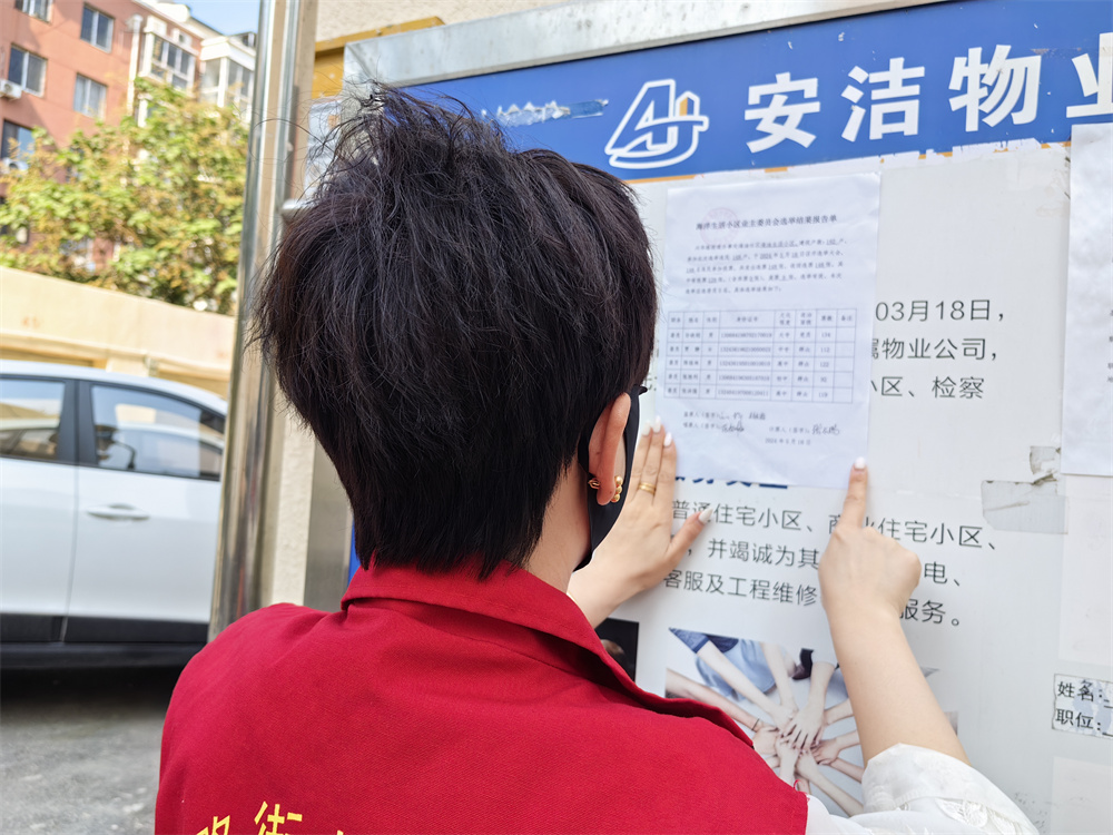 在河北省高碑店市海油社区海洋生活小区内,社区工作人员在公室栏内张贴关于组建海洋生活小区业主委员会的通知。王洪艳摄