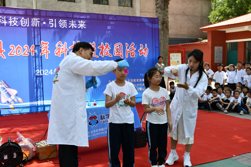 5月23日，科普老师正在和孩子一起做“酚酞酸碱变色”实验。张信波摄