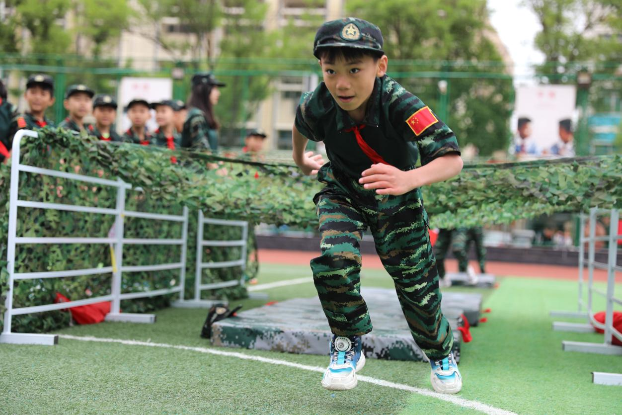 在“穿越火线”游戏环节，学生们穿越障碍，飞奔向前。杨晨摄