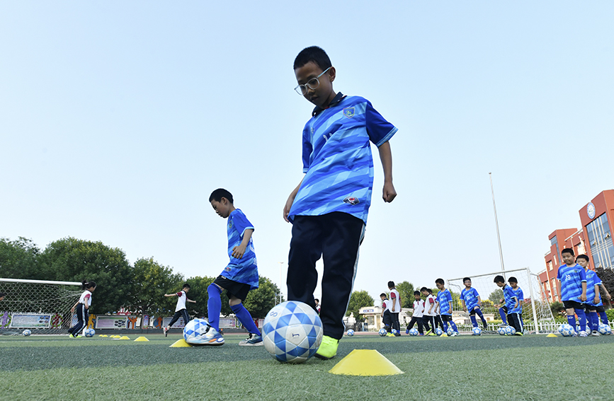  5月21日，在肃宁县第四实验小学，小学生在进行足球训练。苑立伟摄