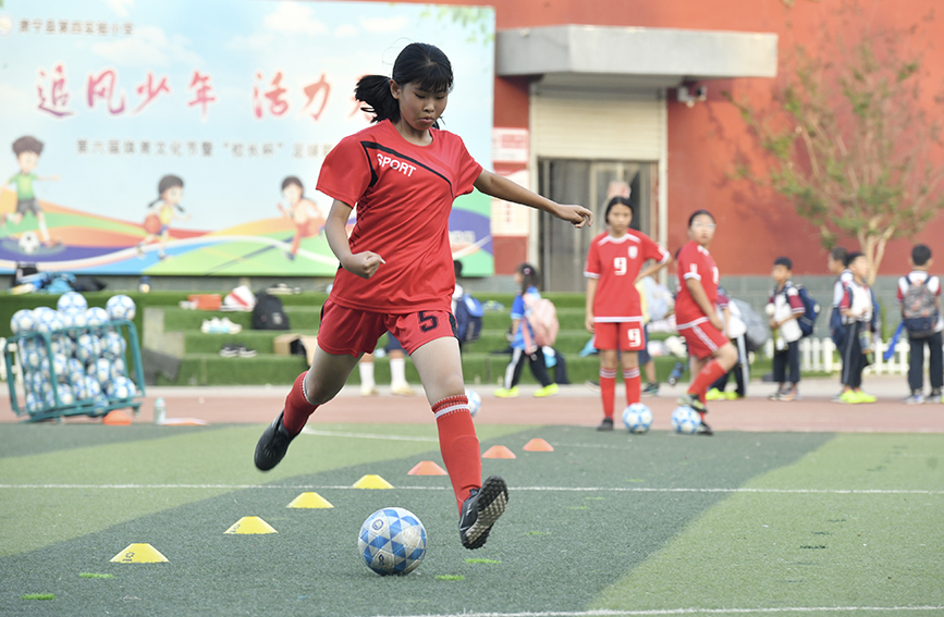  5月21日，在肃宁县第四实验小学，小学生在进行足球训练。苑立伟摄
