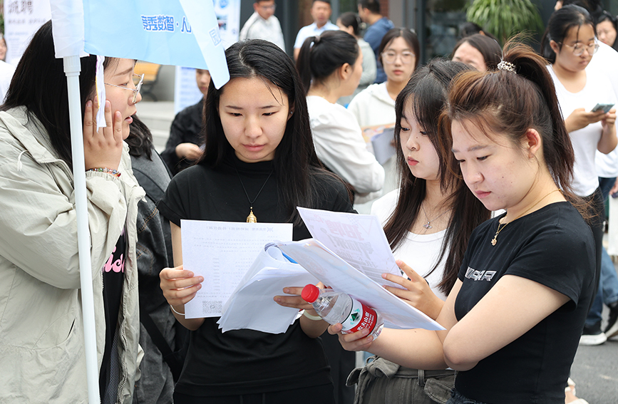 大學畢業生與企業代表認真溝通。杜晶琦攝