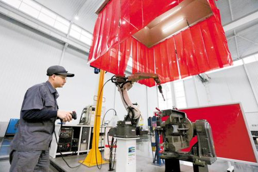 近日，在唐山百川机器人共享工厂，工作人员正调试机器人焊接工作站。 河北日报记者王育民摄