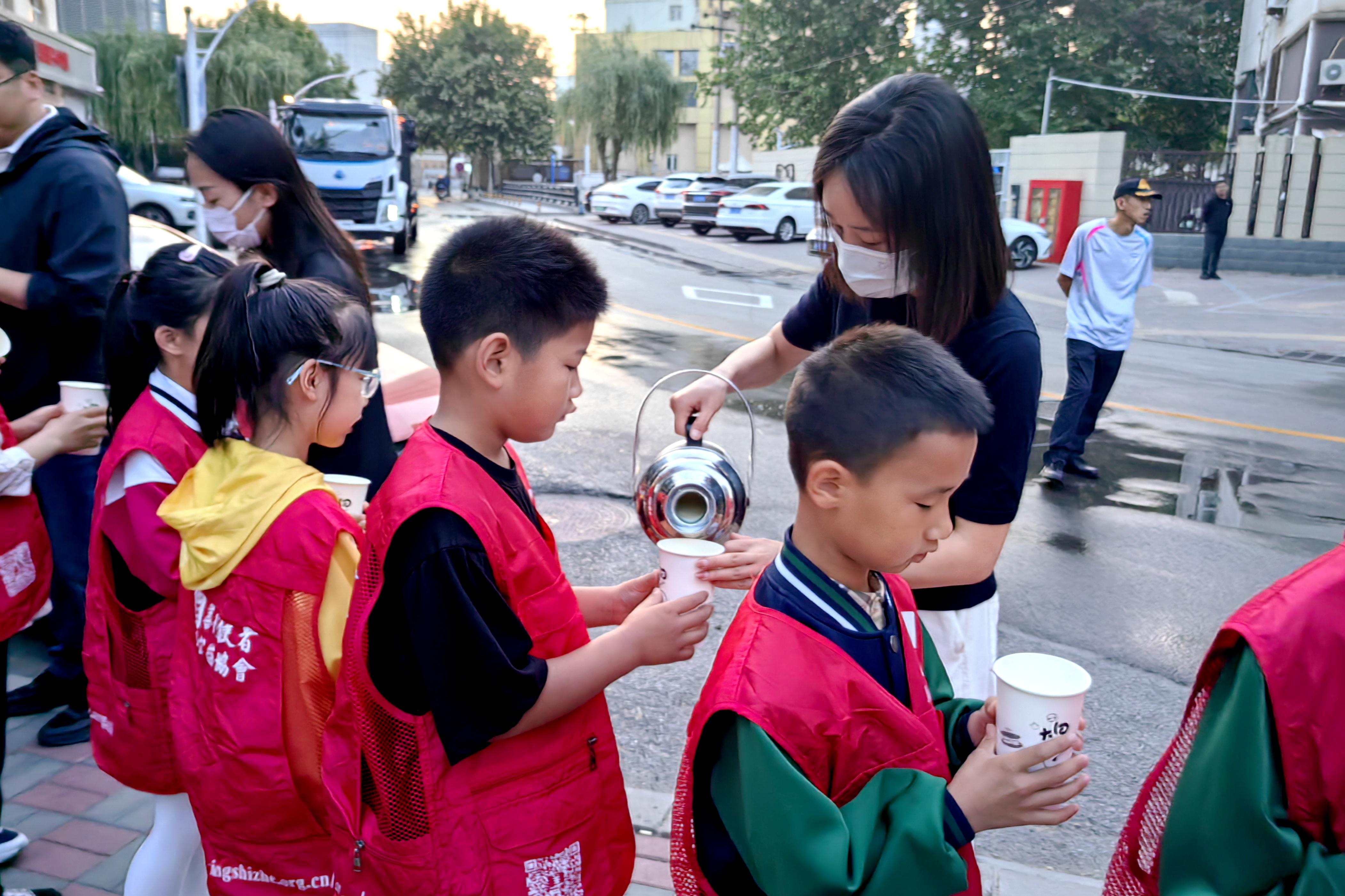 学生们排队领取为环卫工人准备好的豆浆。 石家庄市草场街小学教育集团供图