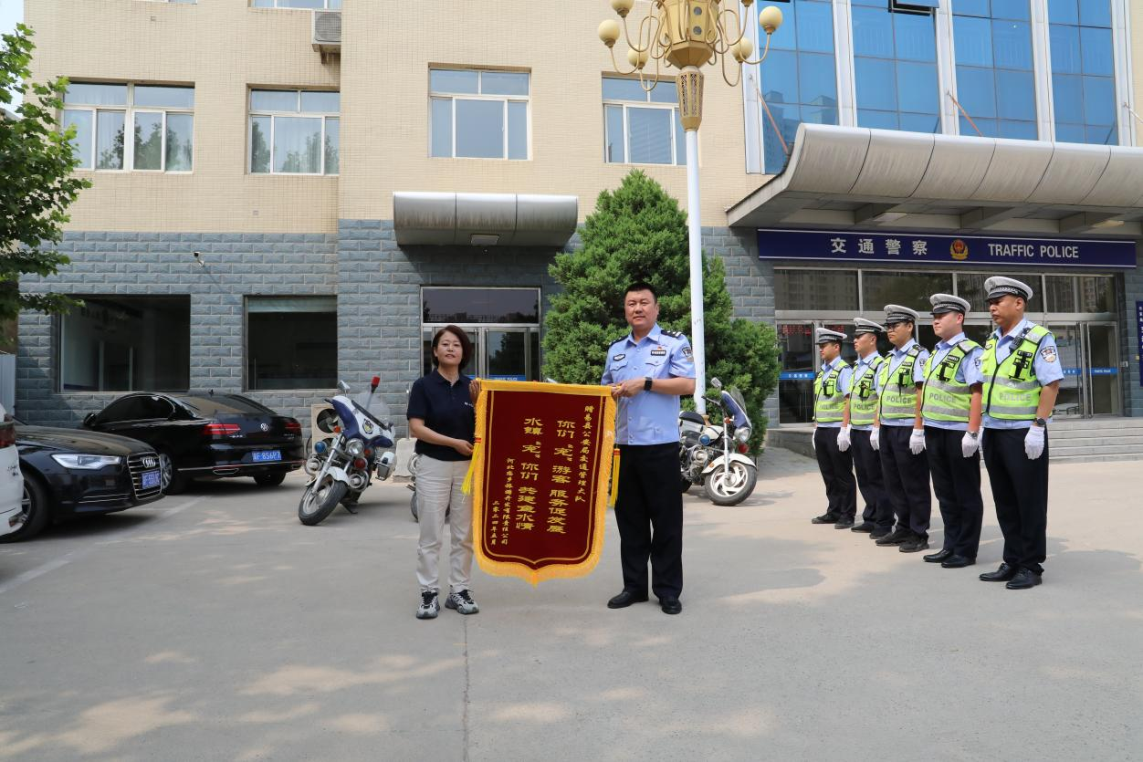 5月23日，河北戀鄉·太行水鎮景區負責人將一面寫有“你們‘寵’游客 服務促發展，水鎮‘寵’你們 共建魚水情”的錦旗送到易縣公安局交通管理大隊。郭恩橋攝