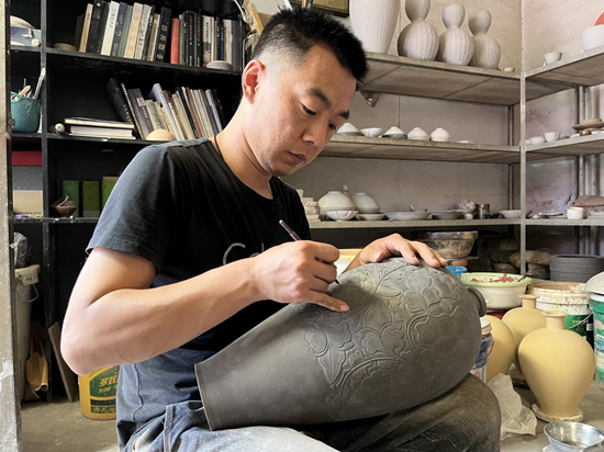 定瓷工匠韩江潮手工刻制定瓷花器梅瓶。李扬摄