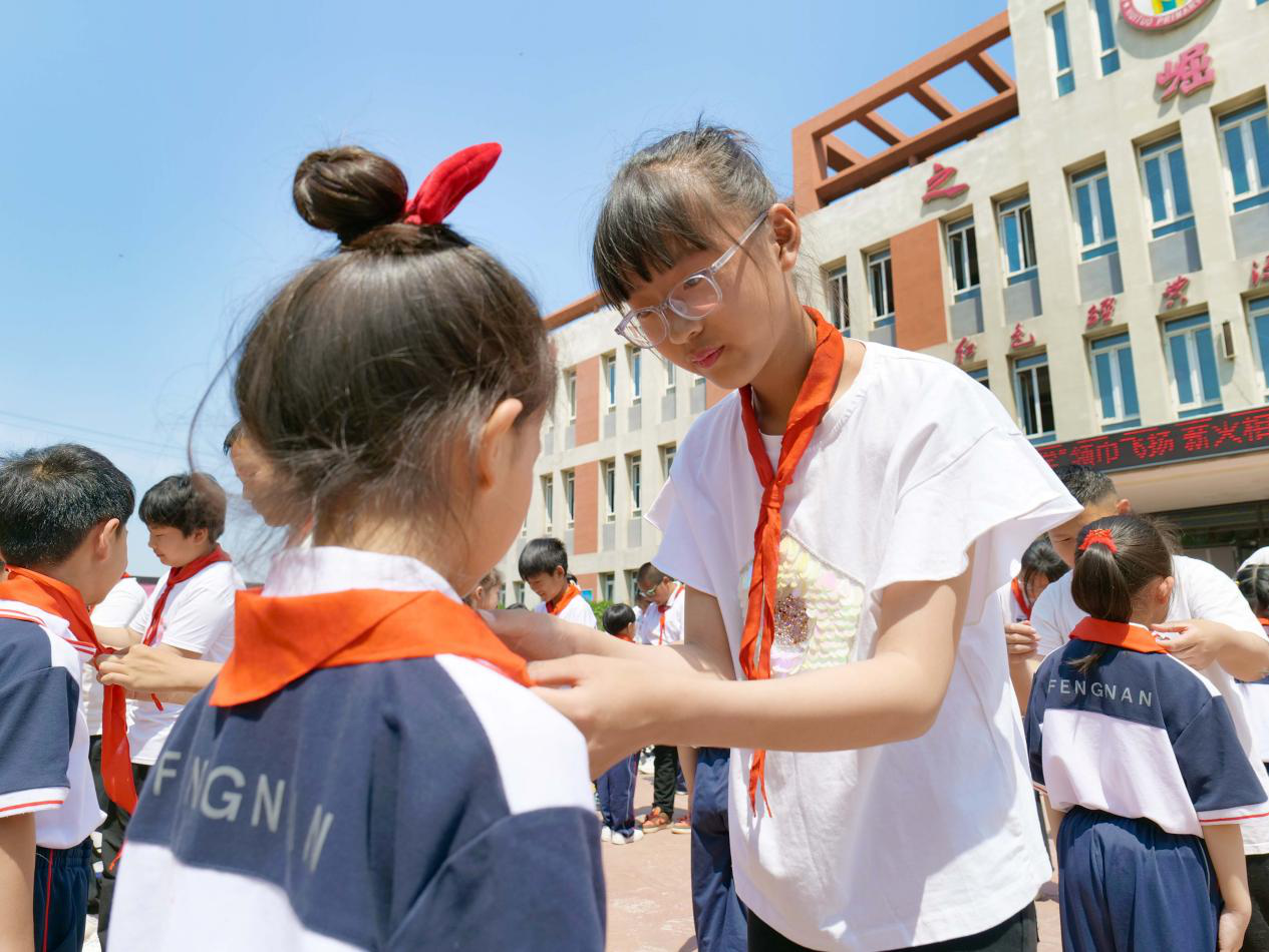 老队员为新队员系上了红领巾。毕帅摄