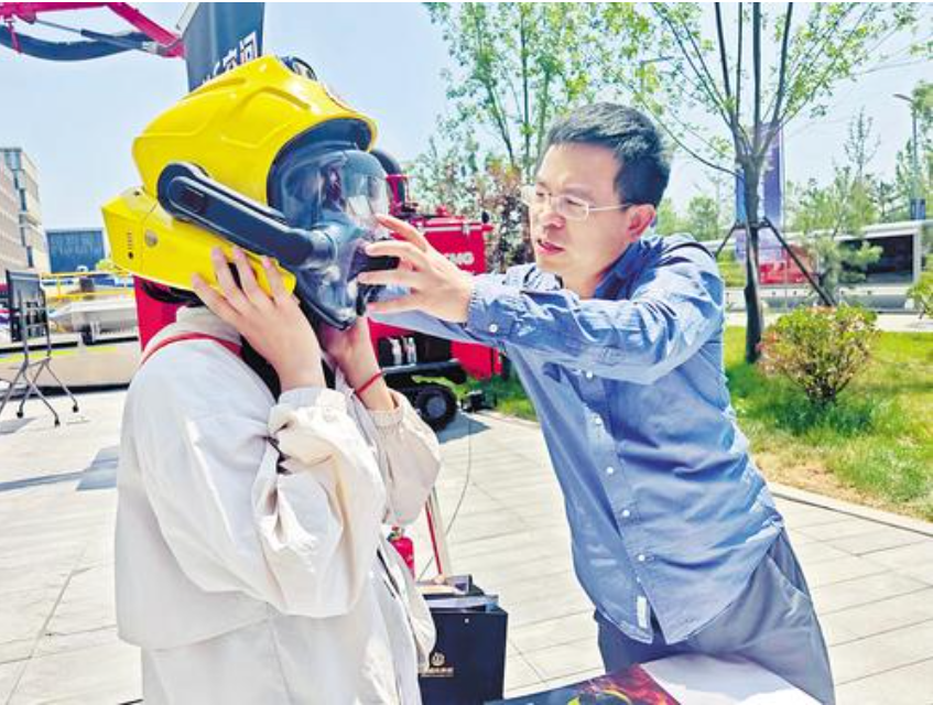 6月3日，在雄安地下空间安全应急技术应用大赛决赛现场，观众正在工作人员的帮助下，体验智能消防头盔。河北日报记者苑立立摄