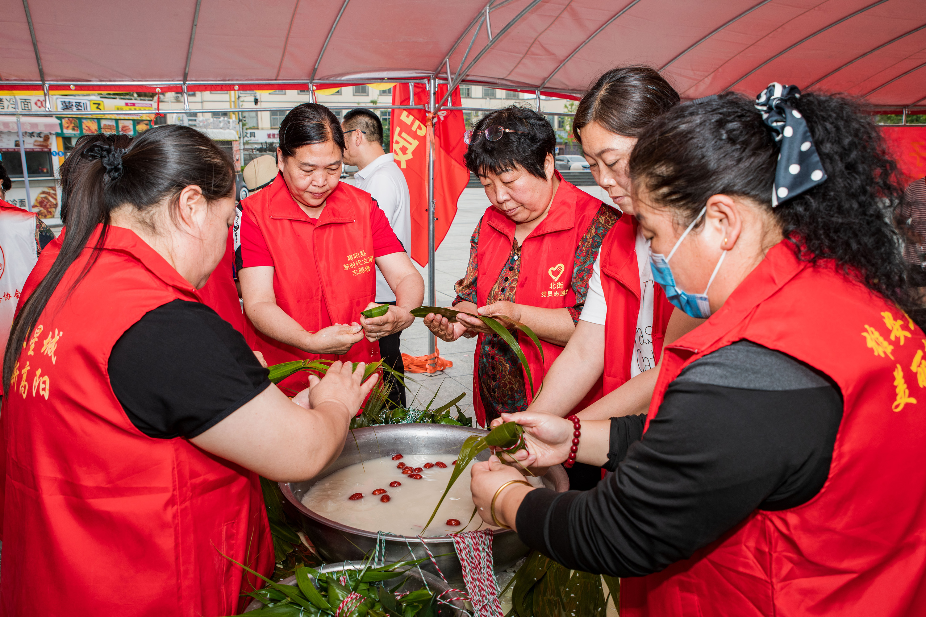 6月5日，高阳县“‘粽’情端午”爱心粽子、毛巾义卖活动现场，志愿者们包粽子。芦建勇摄