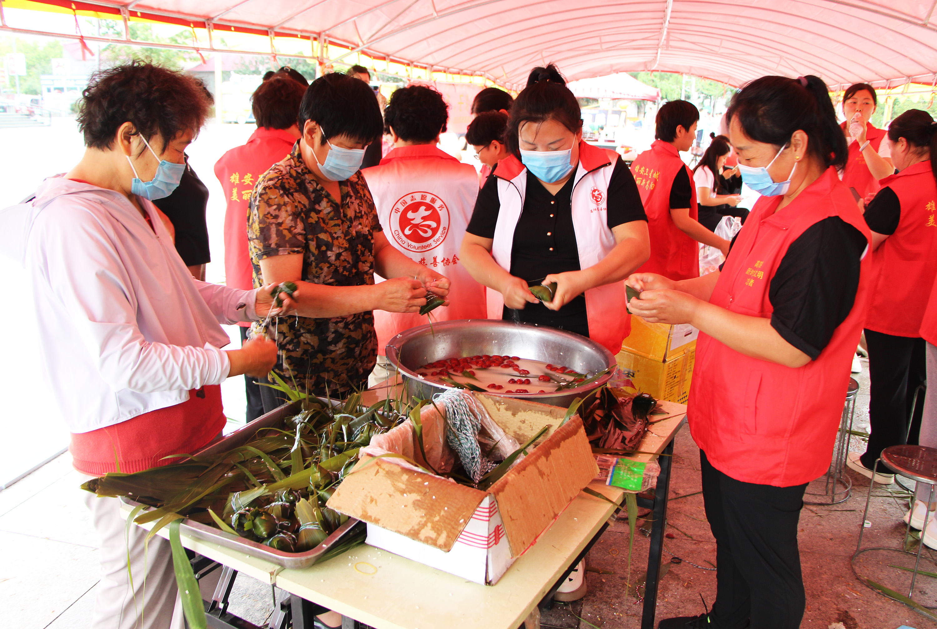 6月5日，高阳县“‘粽’情端午”爱心粽子、毛巾义卖活动现场，志愿者们包粽子。芦建勇摄