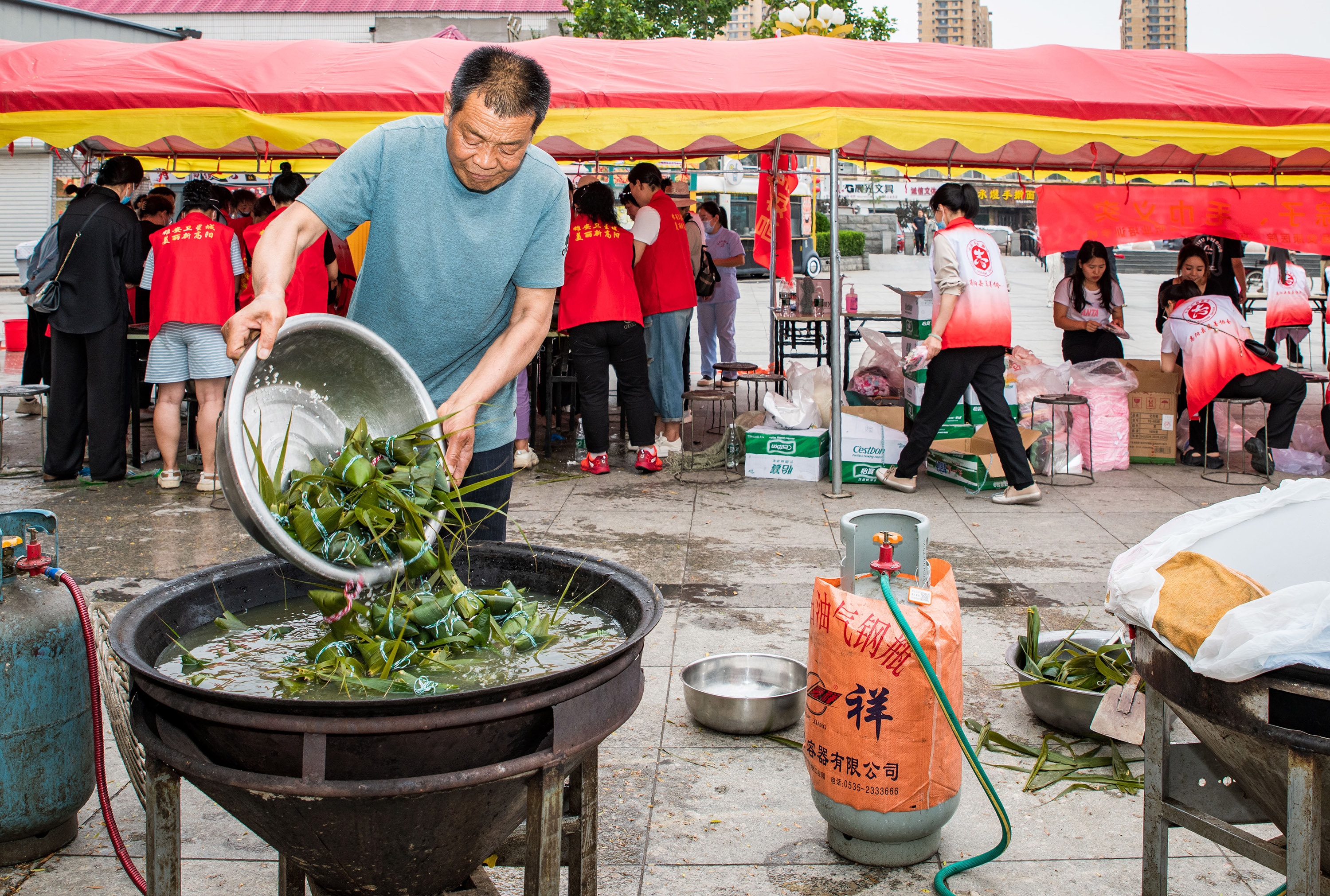 6月5日,高阳县“‘粽’情端午”爱心粽子、毛巾义卖活动现场,志愿者煮粽子。芦建勇摄