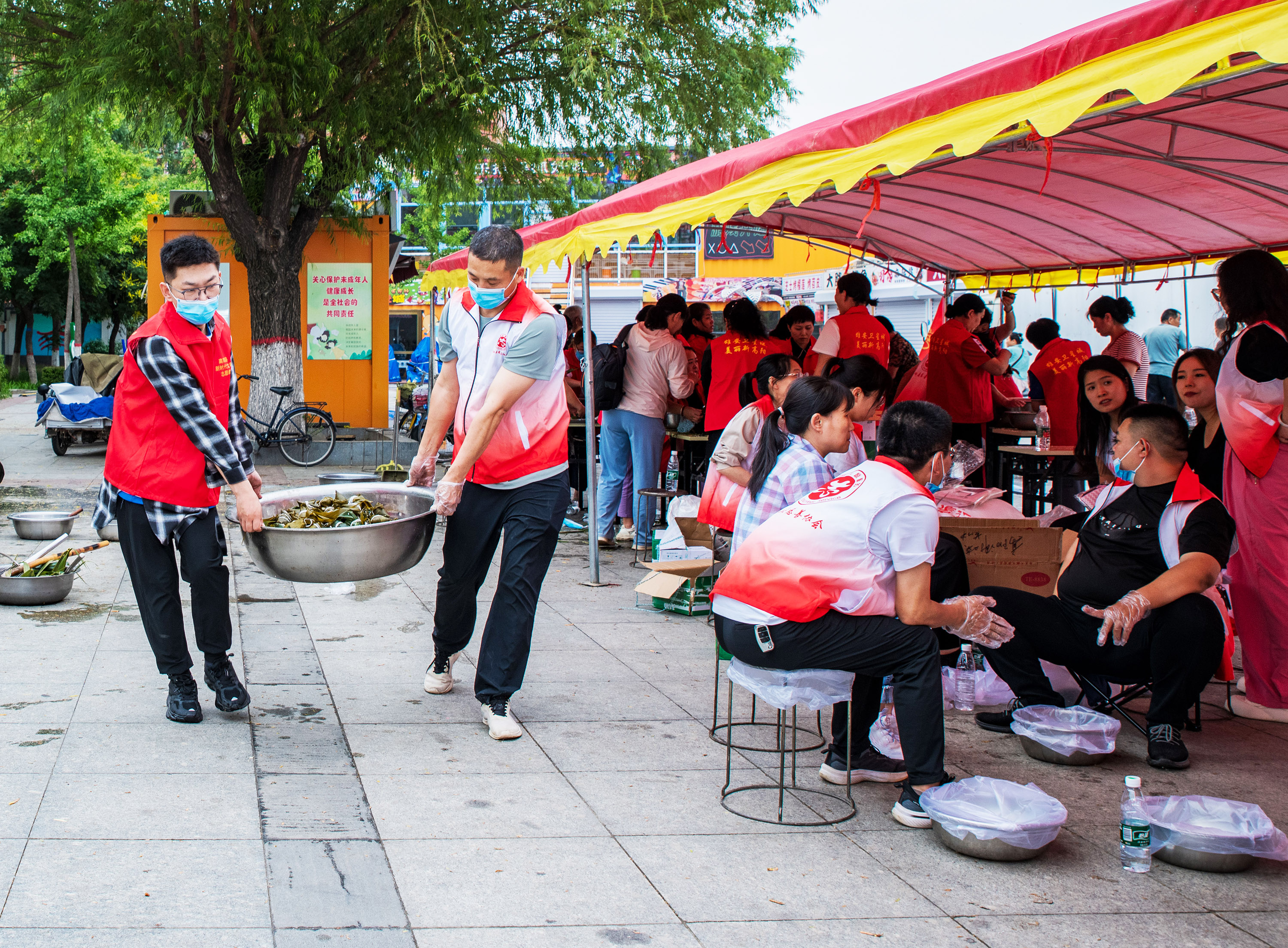 6月5日，高阳县“‘粽’情端午”爱心粽子、毛巾义卖活动现场，粽子煮熟出锅，志愿者抬着煮熟的粽子去售卖。芦建勇摄
