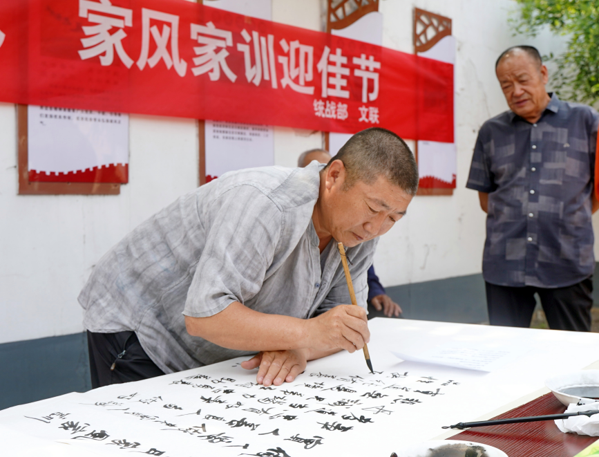 6月6日，迁安市书法爱好者在沙河驿镇李店子村书写家风家训书法作品。张泽慧摄