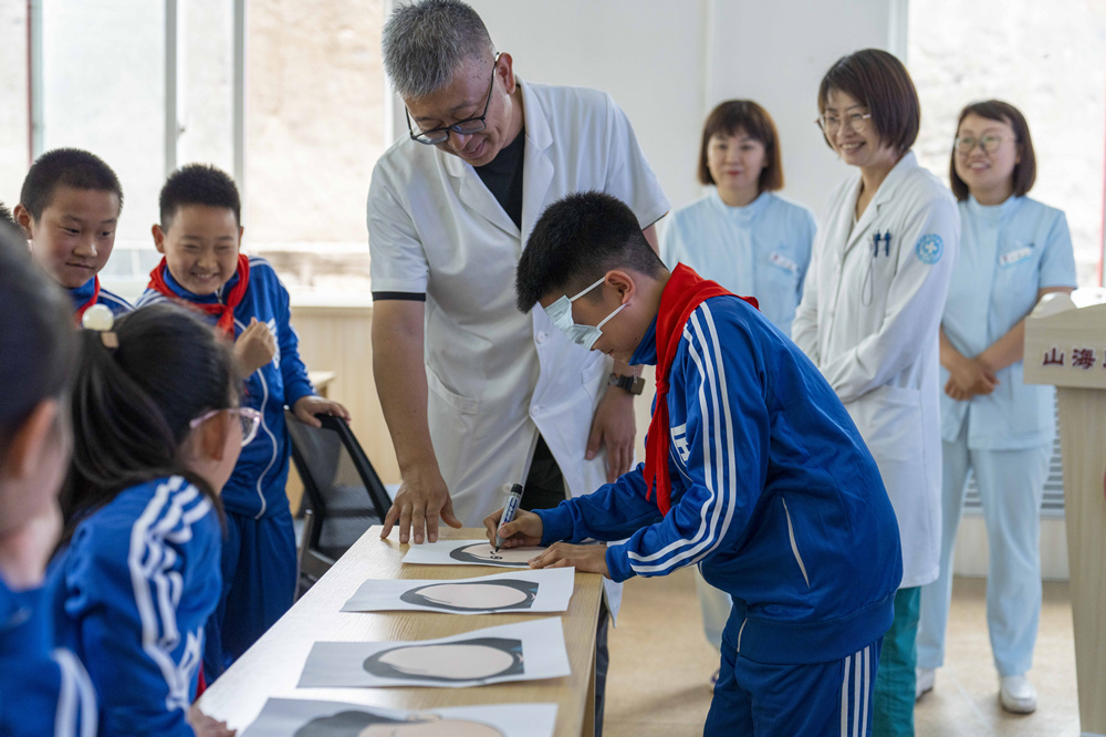 医务人员带领学生们做眼部游戏。郭楠摄
