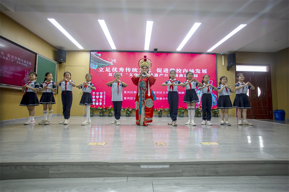 6月6日，河北省邯郸市复兴区阳春小学，复兴区文化馆的老师正在教学生戏曲的步伐、手势和唱腔。聂长青摄