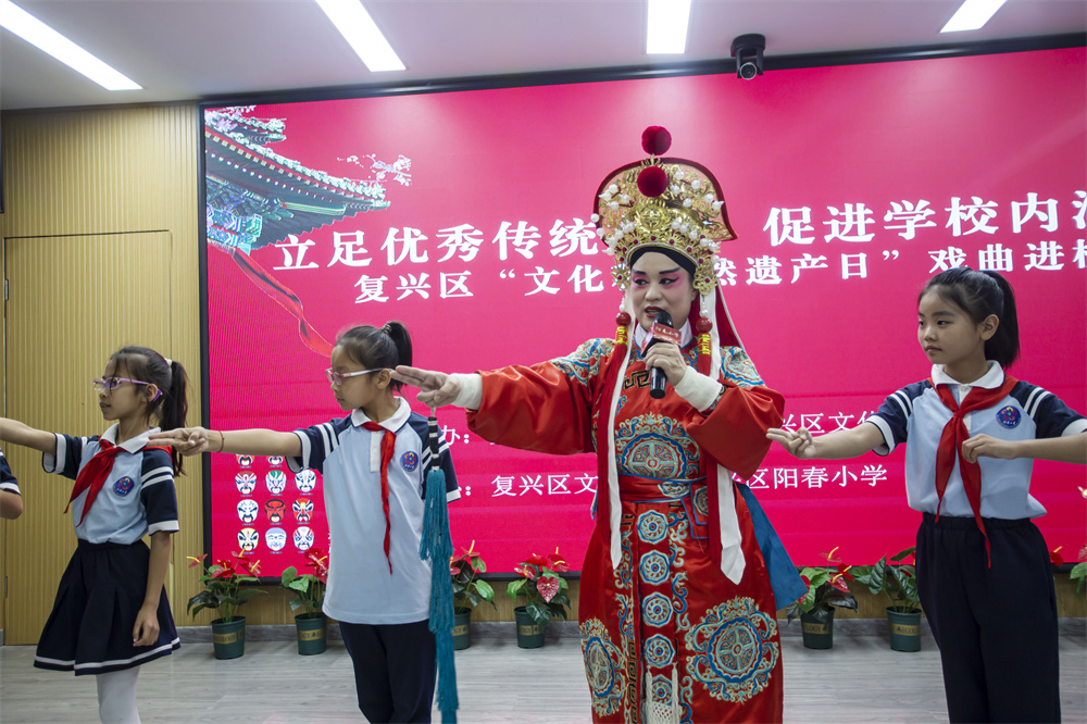 6月6日,河北省邯郸市复兴区阳春小学,复兴区文化馆的老师正在教学生戏曲的步伐、手势和唱腔。聂长青摄